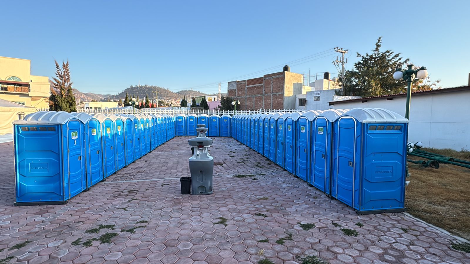 Fila amplia de sanitarios portatiles azules instalados para evento