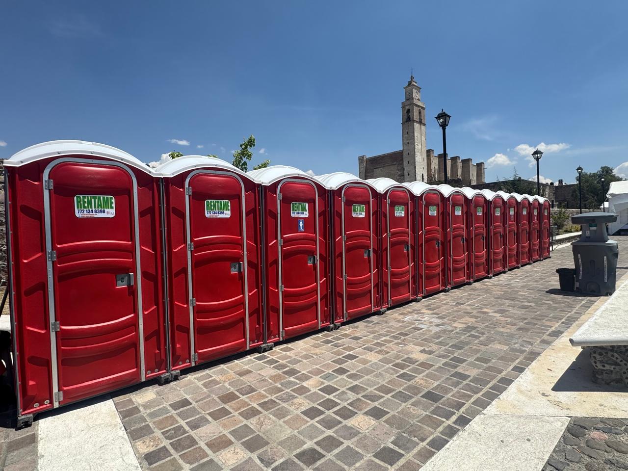 Fila de sanitarios portatiles rojos listos para un evento