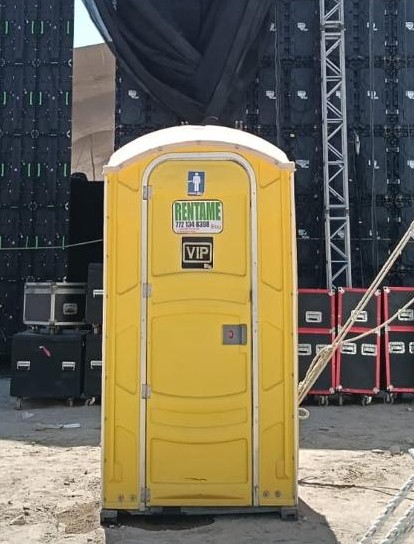 Sanitario portátil VIP amarillo instalado en zona de evento